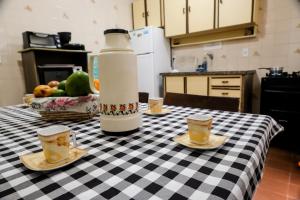 Una mesa con dos tazas y una botella de agua. en Casa Triplex no Peró, en Cabo Frío