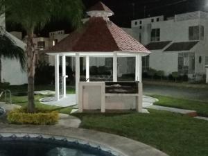 un cenador junto a una piscina por la noche en LINDA CASA DE DESCANSO EN MORELOS, en Cuautla Morelos