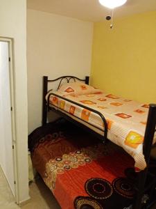 a bedroom with a bunk bed with a comforter at LINDA CASA DE DESCANSO EN MORELOS in Cuautla Morelos