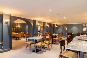 a dining room with tables and chairs in a restaurant at Three Ways House Hotel in Chipping Campden
