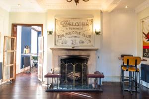 a fireplace in a living room with two stools at Three Ways House Hotel in Chipping Campden