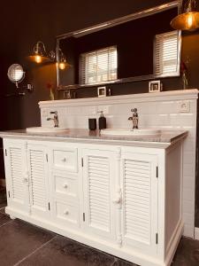 a white bathroom with two sinks and a mirror at The Hampton Hock's - Wellness & Wine in Freinsheim