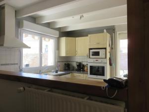 een keuken met een spoelbak en een fornuis bovenste oven bij Clos Saint Hilaire in Longeville-sur-Mer