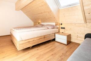 a bedroom with a bed and a wooden floor at Apartment Tschirgant Deluxe in Imst