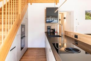 eine Küche mit Arbeitsplatten aus Edelstahl und eine Holztreppe in der Unterkunft Apartment Tschirgant Deluxe in Imst
