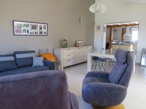 een woonkamer met twee blauwe banken en een keuken bij Clos Saint Hilaire in Longeville-sur-Mer