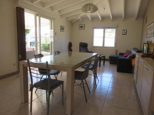 een keuken en woonkamer met een tafel en stoelen bij Clos Saint Hilaire in Longeville-sur-Mer