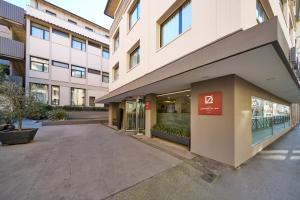 a building with a parking lot in front of it at Hotel Leonardo da Vinci in Florence