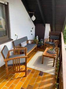 a porch with three chairs and a bench and a table at Engler-Fazekas in Bad Dürrheim