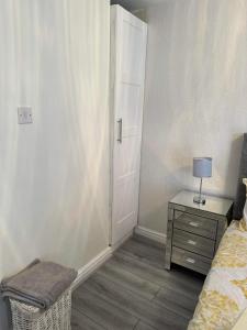 een slaapkamer met een bed en een tafel met een lamp bij Private guest house/Annexe in Manchester
