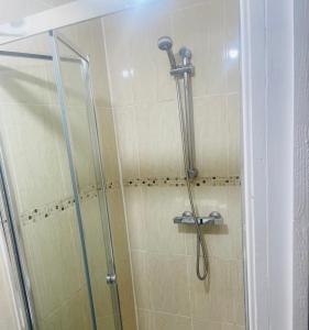 a shower with a glass door in a bathroom at Private guest house/Annexe in Manchester