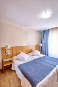 a bedroom with a large bed with a blue blanket at Villa De Llanes in Llanes