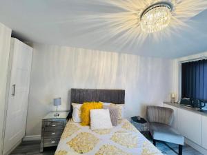 1 dormitorio con cama y lámpara de araña en Private guest house/Annexe, en Mánchester