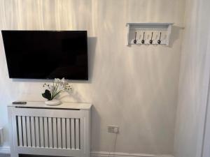 a flat screen tv on a wall in a room at Private guest house/Annexe in Manchester