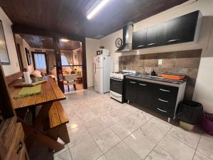 a kitchen with a white refrigerator and a table at Cálida Cabaña en el Corazón de Ushuaia in Ushuaia