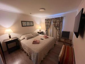 1 dormitorio con 1 cama con 2 toallas en Cálida Cabaña en el Corazón de Ushuaia en Ushuaia