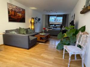 - un salon avec un canapé et une chaise dans l'établissement Modernes Appartement im Grünen, à Cologne