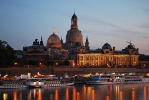 a large building with several boats in the water at City Apart Dresden Apartment 4 in Dresden