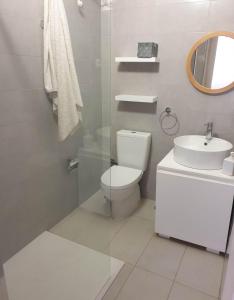ein weißes Bad mit einem WC und einem Waschbecken in der Unterkunft L2B - São Vicente in Mindelo