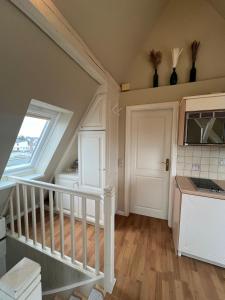 une cuisine avec un escalier, une fenêtre et un four micro-ondes dans l'établissement Haus Momoa Westerland ruhige Lage Strandnaehe nur wenige Gehminuten in die Innenstadt, à Westerland 1 autre photo