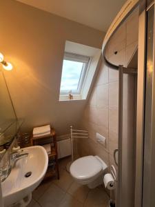 une salle de bain avec toilettes, lavabo et fenêtre dans l'établissement Haus Momoa Westerland ruhige Lage Strandnaehe nur wenige Gehminuten in die Innenstadt, à Westerland