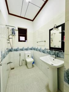 een badkamer met een wastafel, een toilet en een douche bij Gendawana villa in Ambalangoda