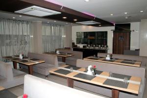 a restaurant with couches and tables and a bar at Veronica Hotel in Vadodara