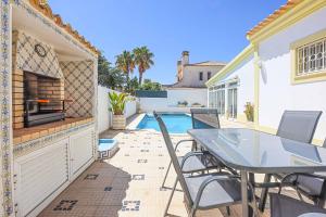 a patio with a table and chairs and a swimming pool at Villa Vivienda Rosa in Albufeira