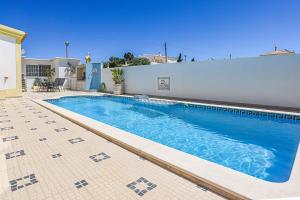 a swimming pool in front of a house at Villa Vivienda Rosa in Albufeira