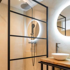 een douche met een glazen deur naast een wastafel bij Hello Zeeland - Vakantiewoning Hoeve De Lente in Breskens