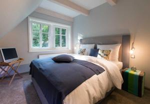 a bedroom with a large bed and a window at Das Landhaus in Bilsen