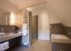 a large bathroom with a tub and a sink and a bath tub at Das Landhaus in Bilsen