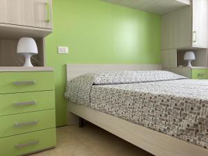 a bedroom with a bed and a dresser with two lamps at Marebello in Rosolina +38 photos