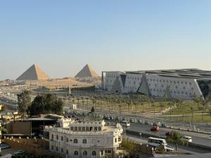 uma vista para um edifício com pirâmides ao fundo em Museum comfort view Giza ' pyramids em Giza
