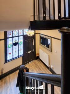 a room with a staircase and stained glass windows at Spacious 6br Home W Patio Free Parking! in Manchester