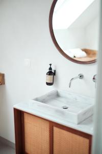 a bathroom with a white sink and a mirror at Penthouse : immersion dans la nature in Durbuy