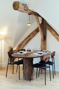 een eetkamer met een houten tafel en stoelen bij Penthouse : immersion dans la nature in Durbuy