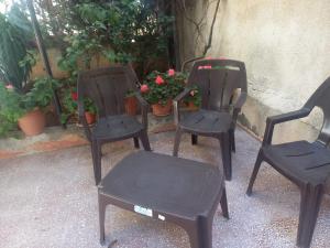 three black chairs and a table and some flowers at شقه مفروشه مع حديقه اربد بجانب مدارس دار العلوم in Irbid