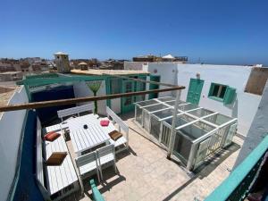 a balcony of a building with a view of the ocean at Riad Dar in Essaouira