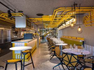 a row of tables and chairs in a restaurant at The Megaro Hotel - Kings Cross St Pancras, London in London