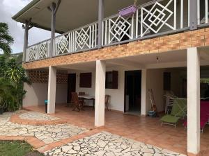 a house with a balcony and a patio at Domaine de kanelle in Rivière-Pilote