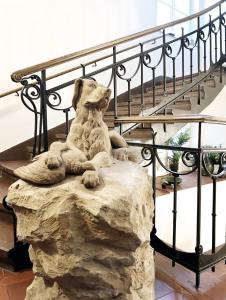 a statue of a dog sitting on a rock next to a staircase at Residence Charles Bridge in Prague