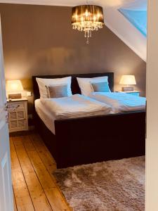 a bedroom with two beds and a chandelier at The Hampton Hock's - Wellness & Wine in Freinsheim +129 photos
