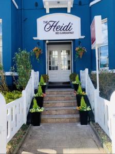 um edifício azul com escadas que levam ao restaurante Helliki em The Heidi Bed & Breakfast em Southport
