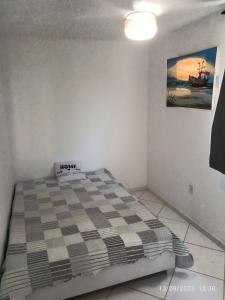 - une chambre avec un lit et une couverture en damier dans l'établissement POUSADA PÉ NA AREIA, à Rio de Janeiro
