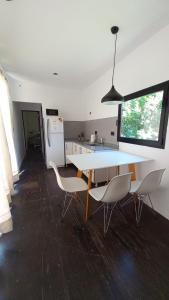 eine Küche mit einem Tisch und Stühlen sowie einem Kühlschrank in der Unterkunft Cubil Amarillo. Casa conteiner 1 dormitorio in General Roca
