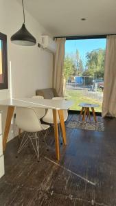 ein Wohnzimmer mit einem Tisch, Stühlen und einem Sofa in der Unterkunft Cubil Amarillo. Casa conteiner 1 dormitorio in General Roca