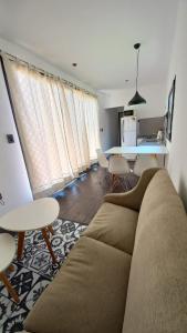 ein Wohnzimmer mit einem Sofa und einem Tisch in der Unterkunft Cubil Amarillo. Casa conteiner 1 dormitorio in General Roca