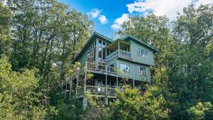 a large green house in the middle of trees at Rubys Roost in Mentone