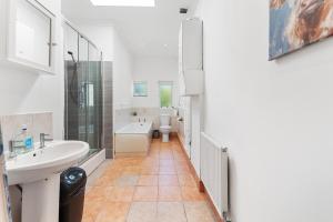 a white bathroom with a sink and a toilet at The Two-Bedroom Haven- Sleeps 10 in St. Albans